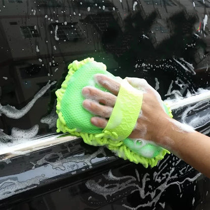Person cleaning a car window with a green sponge