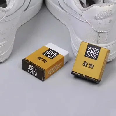 Two 'Shoe Dog' boxes with white sneakers in the background