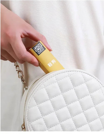 Hand holding a yellow product next to a white quilted bag